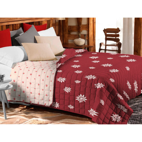 Copriletto trapuntato Edelweiss rosso con fiori bianchi su letto rustico